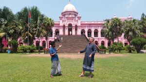 Tourist & Guide on traditional Dress (Lungi) in front of Pink Palace.